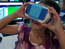Girl looks through VR goggles during a coding for kids class